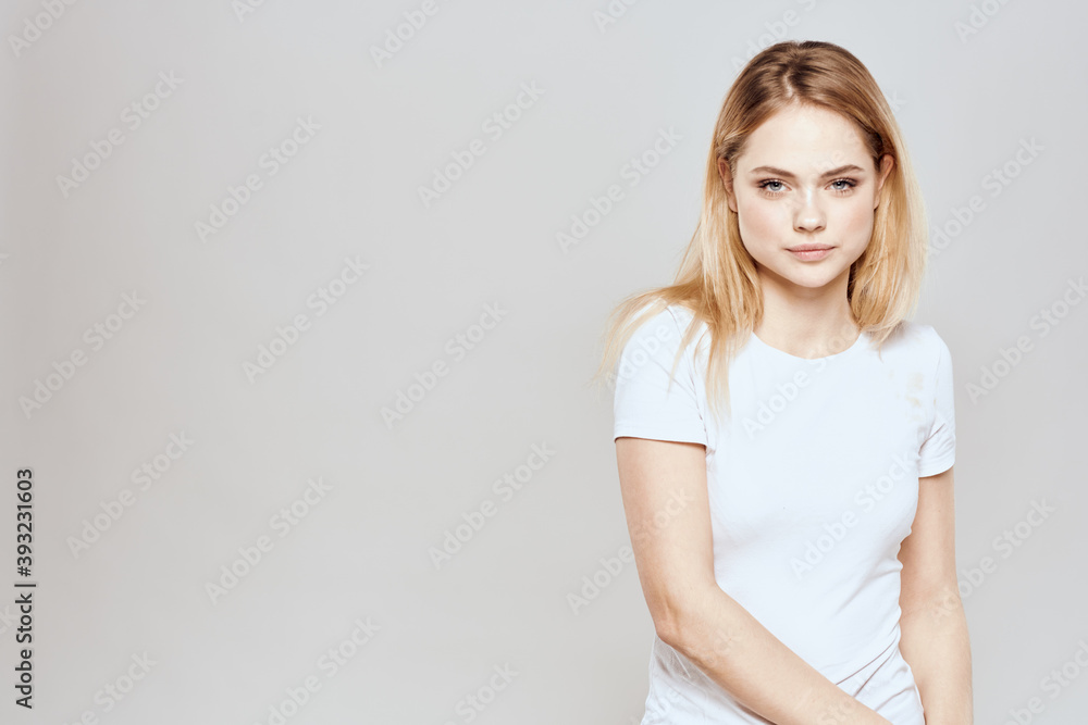 Cute blonde white t-shirt gesture with hands lifestyle light background Cute blonde white t-shirt gesture with hands lifestyle light background