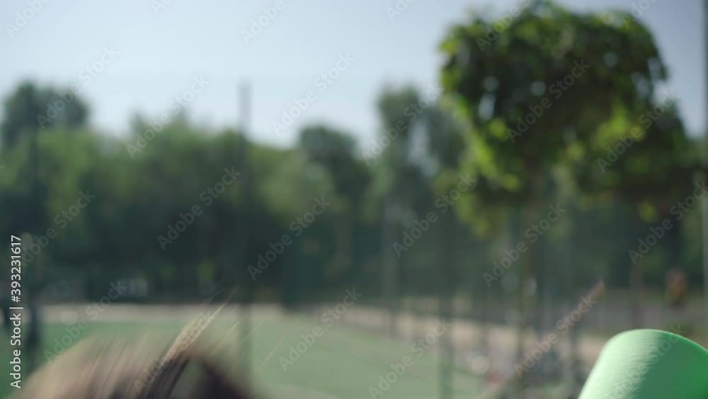 Side view close-up of beautiful Caucasian sportswoman standing in sunlight and drinking water from bottle. Brunette confident woman choking and leaning forward. Side view close-up of beautiful Caucasian sportswoman standing in sunlight and drinking water from bottle. Brunette confident woman choking and leaning forward.