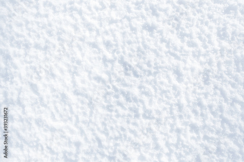 White snow winter texture. Christmas holiday background. Seasonal fresh white colour snow nature backdrop wallpaper.Crisp shiny ice frosty snow on sunny day outdoors. View from above.