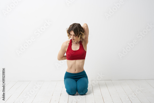the girl is engaged in yoga on a light background Red T-shirt gesticulating with his hands