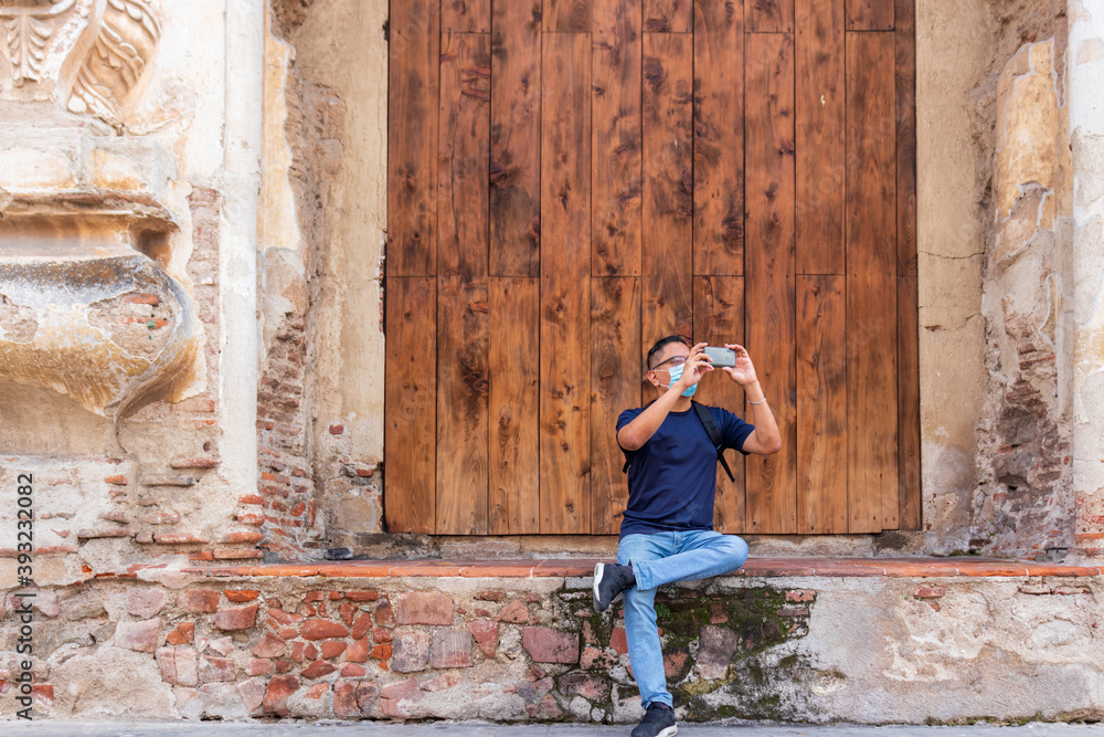 young hispanic man taking photo in antigua guatemala