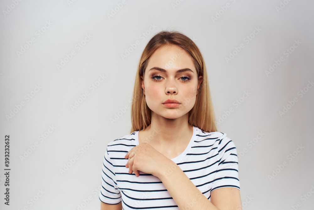 emotional woman in striped t-shirt gesture with hands lifestyle light background emotional woman in striped t-shirt gesture with hands lifestyle light background