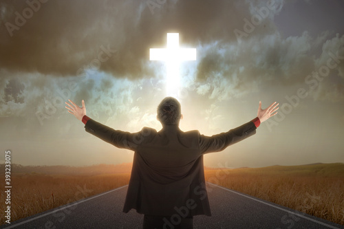 Rear view of Asian businessman raised hands and praying to god