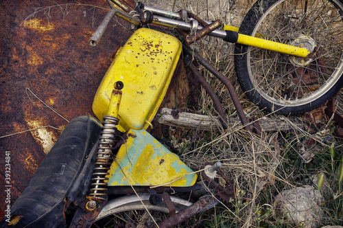 High angle shot of an old rusty and abandoned motorcycle in the field photo