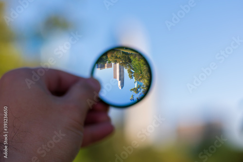 person holding glass of city reflection