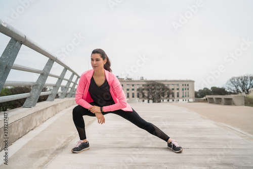 Athletic woman stretching legs before exercise.