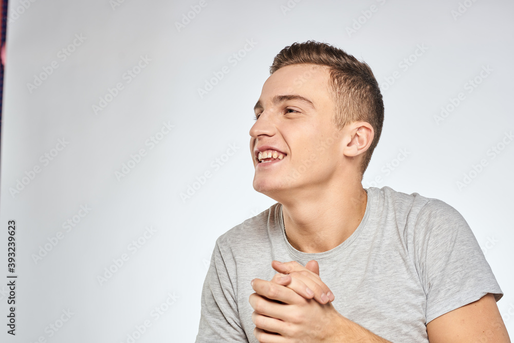 Cheerful emotional man gray t-shirt gesturing with hands studio lifestyle Cheerful emotional man gray t-shirt gesturing with hands studio lifestyle
