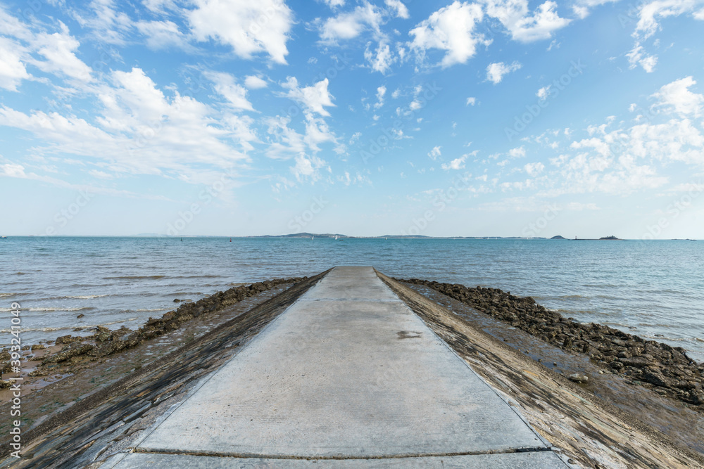 The reef dam protruding into the sea, against blue sky background, Xiamen