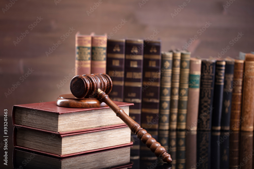 Law theme. Judge chamber. Judge’s gavel and collection of legal books on the brown desk and the brown background. Law theme. Judge chamber. Judge’s gavel and collection of legal books on the brown desk and the brown background.