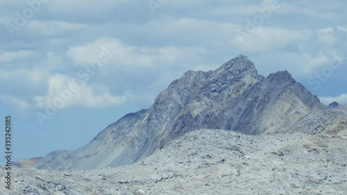 Smooth rotating shot of mystical rocky mountain top in the Sierras with clouds in the sky (60 fps slowed to 24 fps) photo