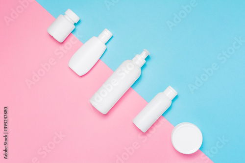 Set of cosmetic mock up for branding on pastel pink and blue background. Tubes, dispensers and jars. Branding identity mockup concept. Flat lay