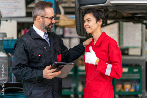 Manager advising the new employees in garage background business concept
