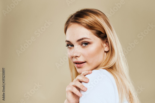 Cheerful blonde gesturing with her hands studio beige background