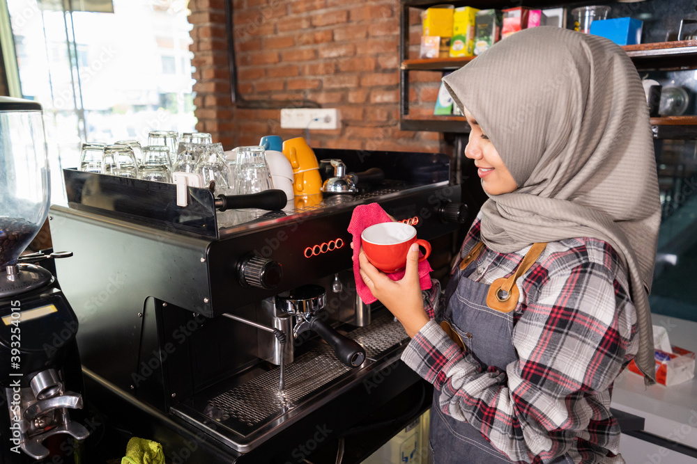 closeup smiling barista getting ready to prepare a glass for customer in a cafe closeup smiling barista getting ready to prepare a glass for customer in a cafe