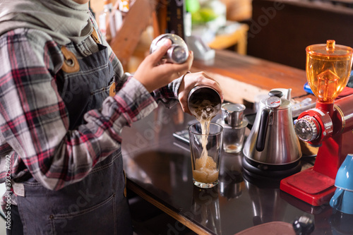 barista make a mixed drink for a customer in a cafe