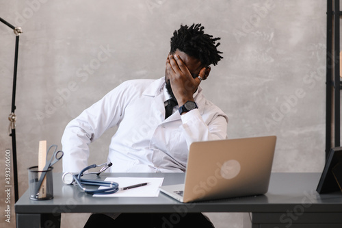 Funny bored at work african american doctor worker falling asleep at office desk, employee sleeping at workplace near laptop feel overworked concept