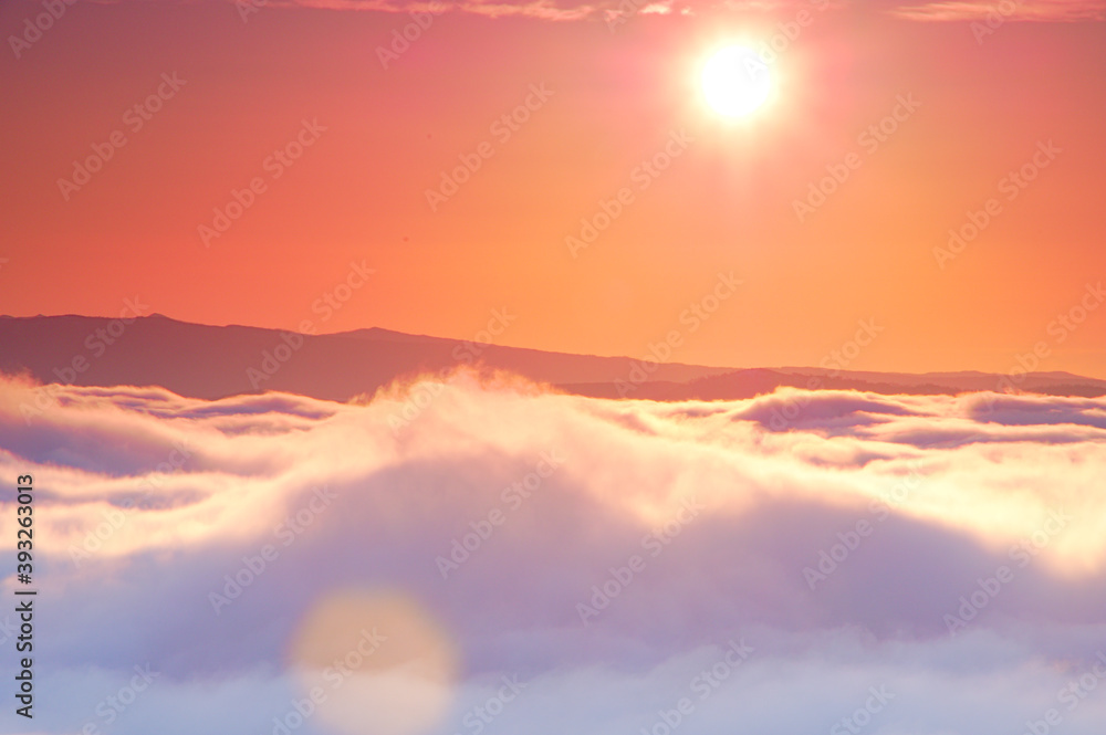 雲海と太陽。大地を覆う雲と壮大な空の風景。