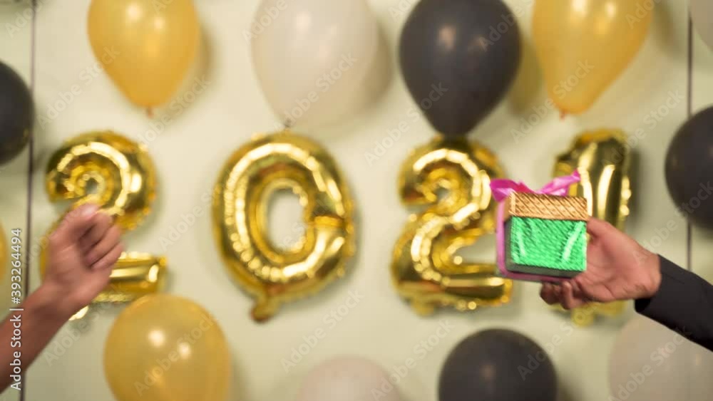 Close up of hands giving present gift box in 2021 new year celebration on decorated background - Concept of gift sharing on new year holydays Close up of hands giving present gift box in 2021 new year celebration on decorated background - Concept of gift sharing on new year holydays