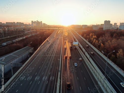 Aerial view panorama of multi-level transport interchange in the center of the big city at dawn. Beautiful panoramic landscape infrastructure of modern city from great height