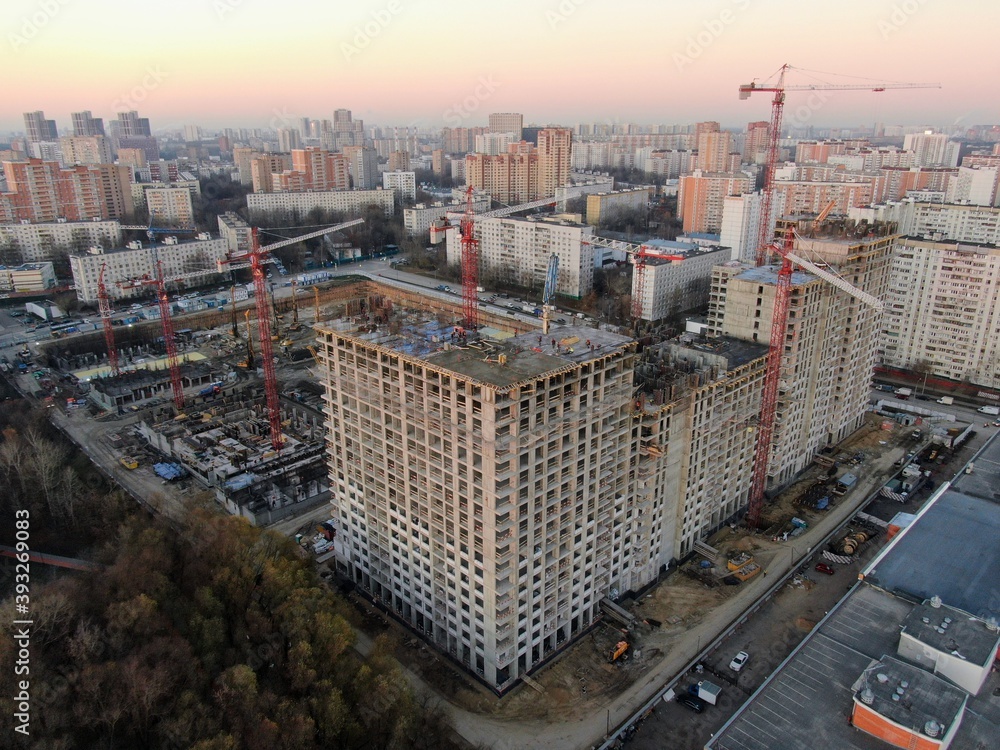 Fototapeta premium Aerial view construction of a high-rise business center in the big city. Beautiful panoramic landscape of the city at dawn from a height.