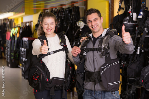 Adult woman and man are satisfied of new diving vest in the diving store