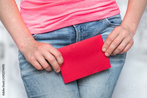 Woman with incontinence problem with red blank paper photo