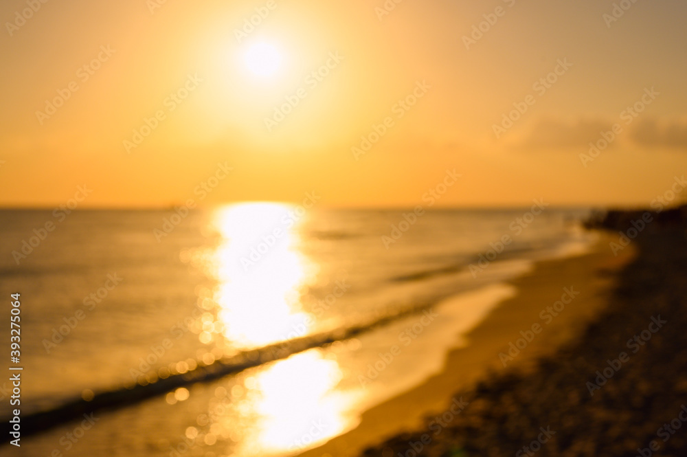 Sunset over the seashore. Background on the theme of the sea and nature. Image is out of focus