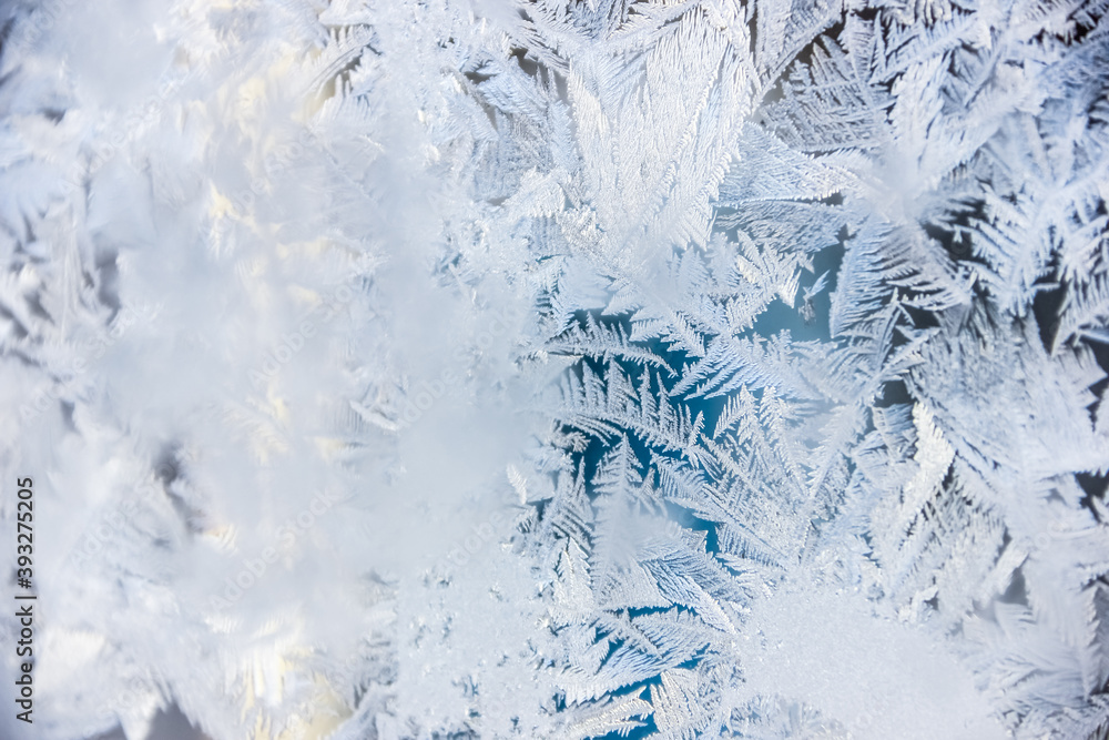 Texture of blue frost on a glass window. Frosty cold weather. White ice patterns texture close-up. New year and Christmas background Texture of blue frost on a glass window. Frosty cold weather. White ice patterns texture close-up. New year and Christmas background