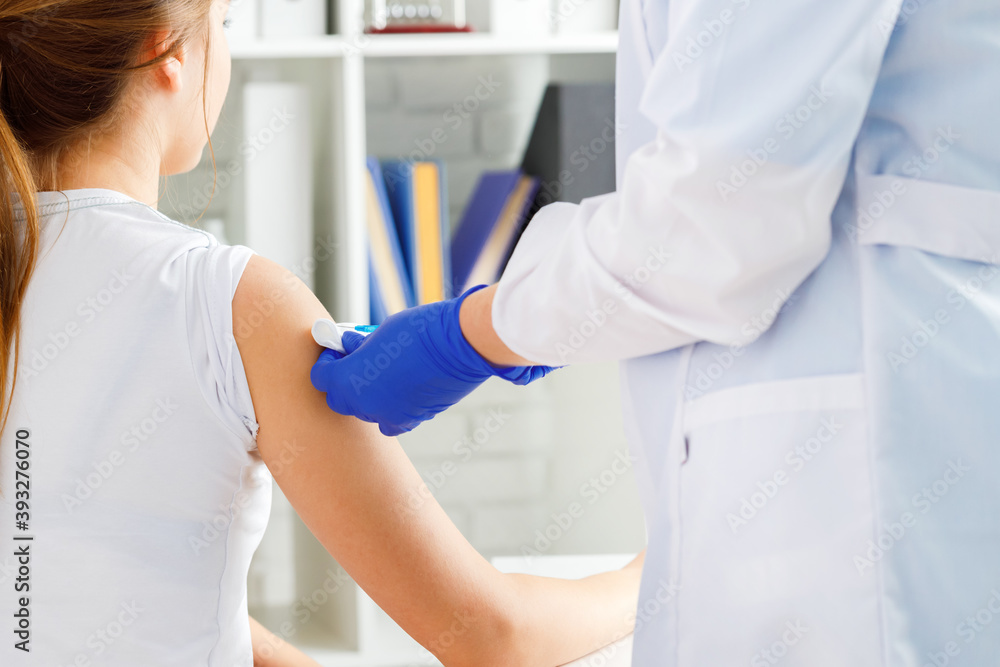 Doctor hands making a vaccination in the shoulder of patient Doctor hands making a vaccination in the shoulder of patient