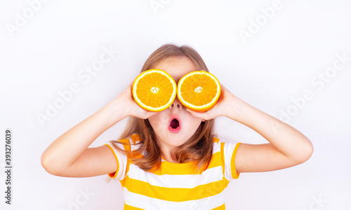 Very surprised little girl with orange halves near her eyes.