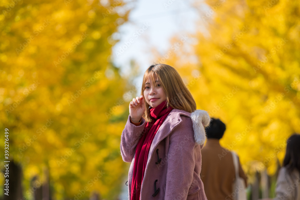 イチョウ並木にいる若い女性 イチョウ並木にいる若い女性
