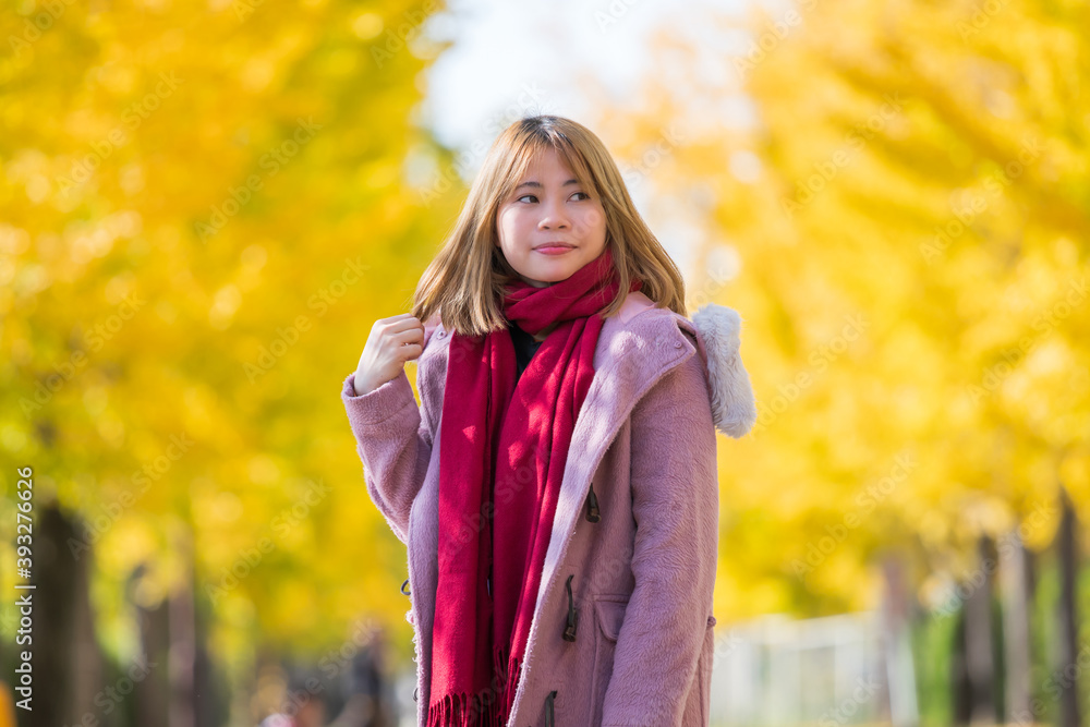 イチョウ並木にいる若い女性 イチョウ並木にいる若い女性