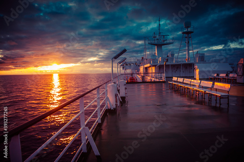 The ferry goes over the sea in the sunset