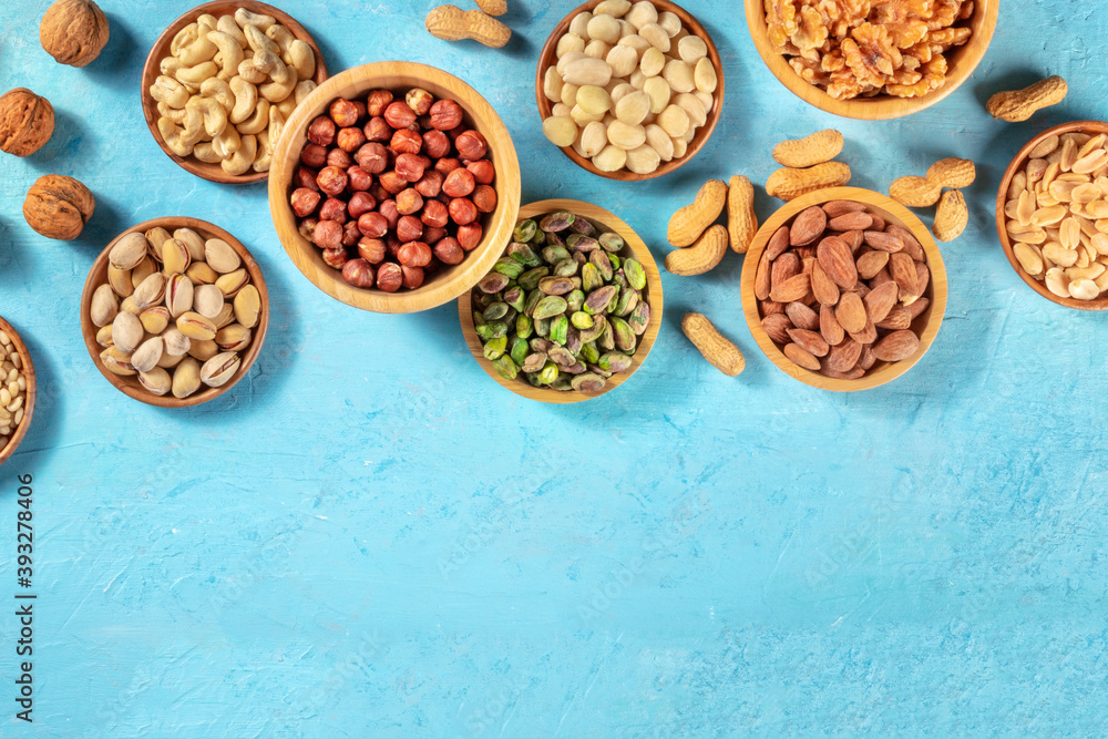 Nuts assortment, shot from the top with a place for text on a vibrant blue background Nuts assortment, shot from the top with a place for text on a vibrant blue background