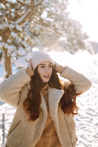 Beautiful woman enjoys winter, frosty day. Fashion young woman in the snow forest. Holidays, season and leisure concept. Christmas, New year.