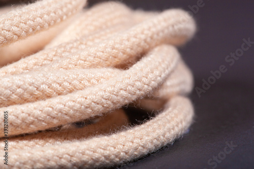 macro photo of new beige shoelaces with on a black background