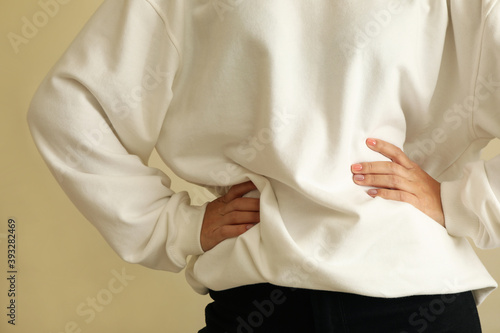 Woman in sweatshirt keep hands on belt