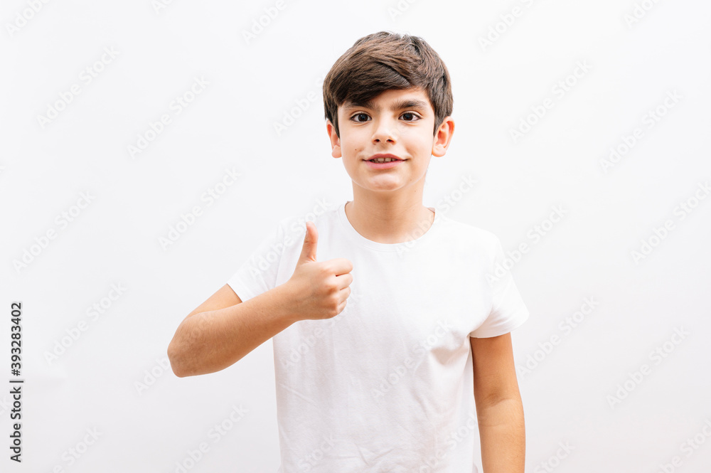Dark haired little child happy with big smile doing ok sign, thumb up with fingers, excellent sign Dark haired little child happy with big smile doing ok sign, thumb up with fingers, excellent sign