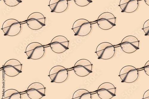 Eyeglasses pattern on a beige background. Creative fashion layout.