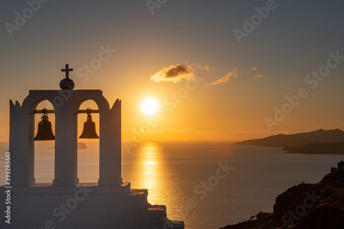 Sunset view across Santorini caldera. Chapel in the foreground. 