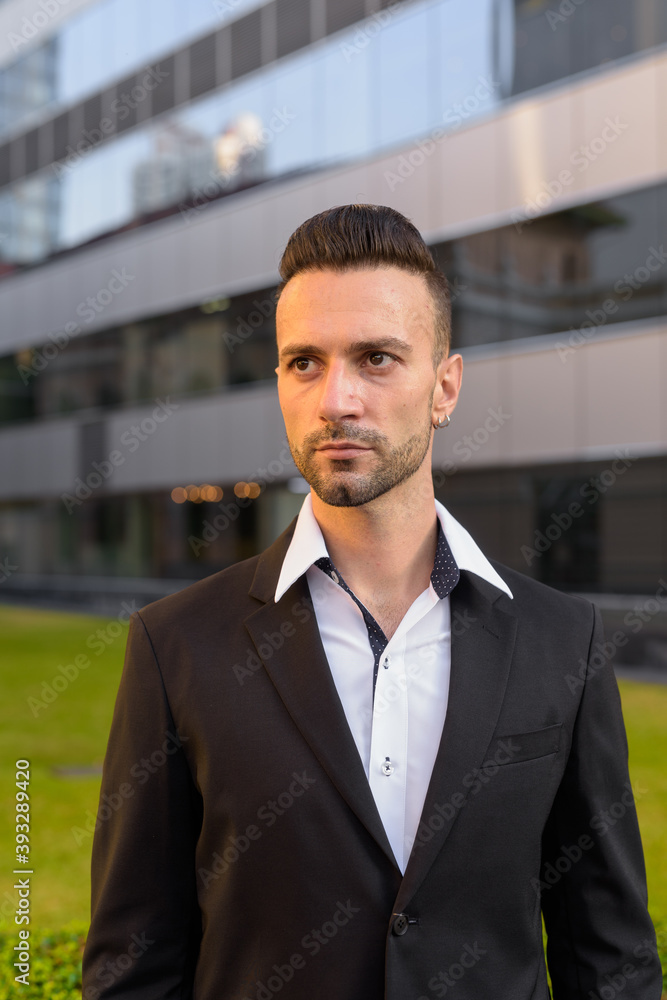 Young businessman thinking outdoors in city vertical shot Young businessman thinking outdoors in city vertical shot
