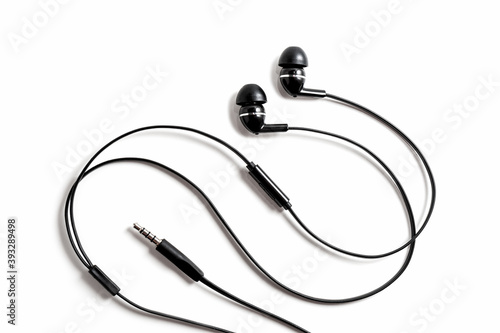 Black wired vacuum earplugs isolated on a white background. Headphones headset. In-ear headphones for listening music and sounds on portable devices for music lovers.
