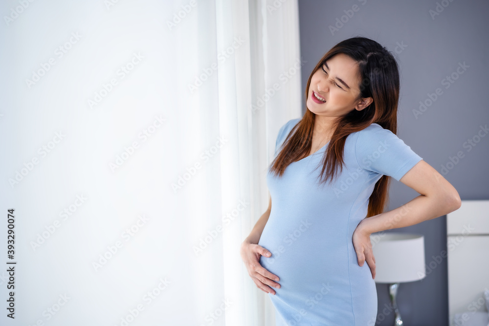 pregnant woman suffering lower back pain in bedroom pregnant woman suffering lower back pain in bedroom