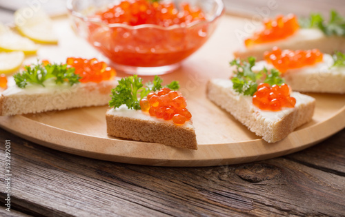 toast with red caviar on wooden tray