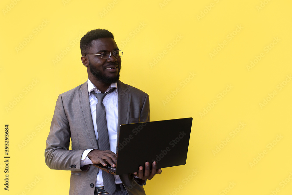 Image of happy excited young african man isolated over yellow background using laptop computer. Image of happy excited young african man isolated over yellow background using laptop computer.