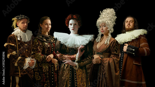 Medieval people as a royalty persons in vintage clothing posing proud and confident on dark background. Concept of comparison of eras, modernity and renaissance, baroque style. Creative collage. photo