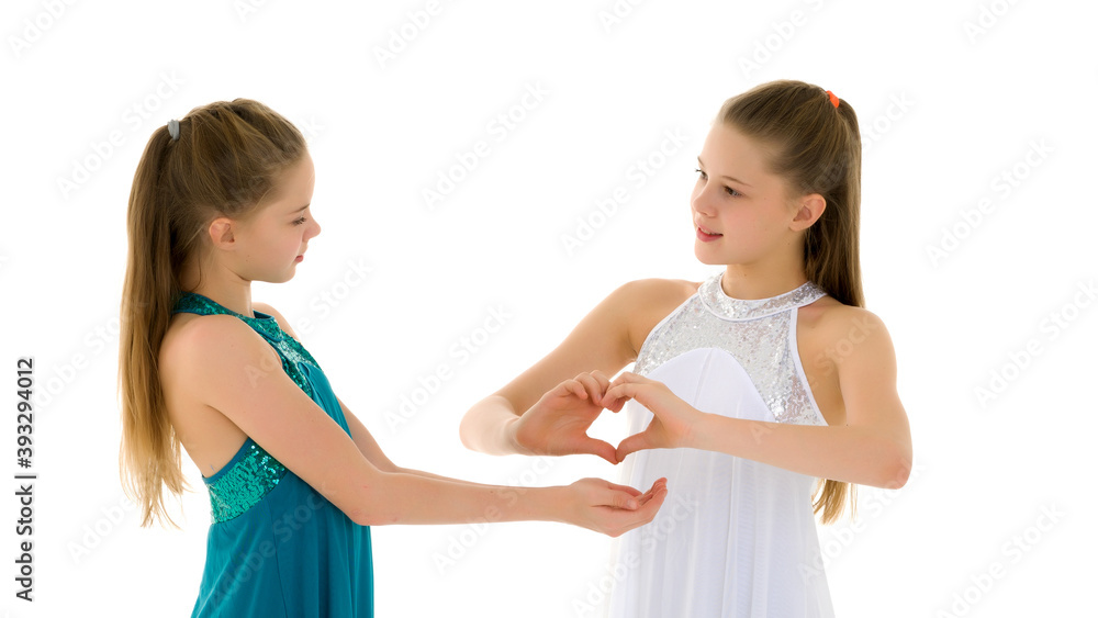 Two adorable girls gymnasts folded palms in the shape of a heart Two adorable girls gymnasts folded palms in the shape of a heart