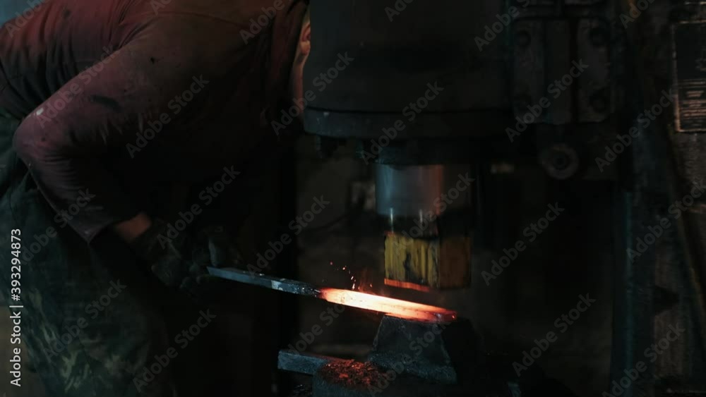 Closeup of Hydraulic Hammer Shaping the Red-Hot Billet. Slow Motion. The Process of Forging of Metal in a Smithy. Metalworking. Blacksmithing Workshop. Closeup of Hydraulic Hammer Shaping the Red-Hot Billet. Slow Motion. The Process of Forging of Metal in a Smithy. Metalworking. Blacksmithing Workshop.