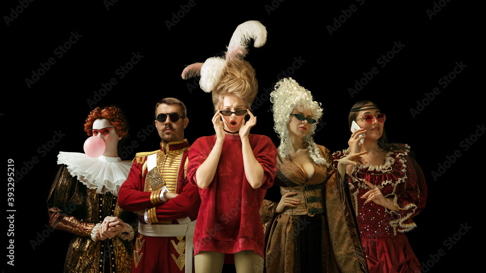 Medieval people as a royalty persons in vintage clothing and modern eyewear using devices on dark background. Concept of comparison of eras, modernity and renaissance, baroque style. Creative collage.
