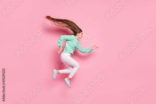 Fototapeta Naklejka Na Ścianę i Meble -  Full body profile portrait of energetic nice lady run jump hair fly turquoise pullover isolated on pink color background